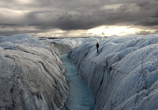 A supraglacial meltwater stream cuts a canyon through the surface of the Greenland ice sheet