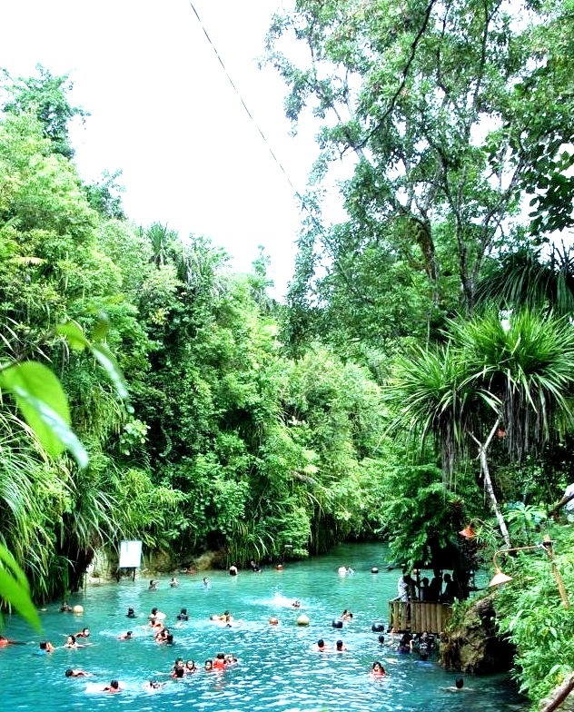 Tourists having fun at The Enchanted River in Surigao del Sur, Philippines